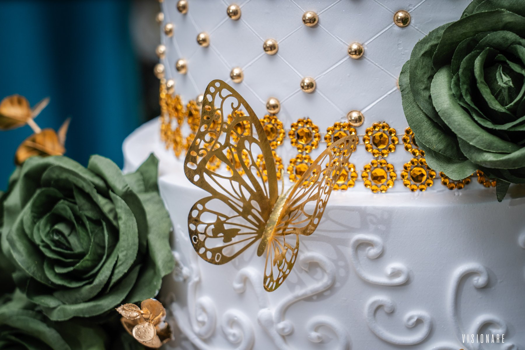 Detalle de mariposa dorada y rosas verdes