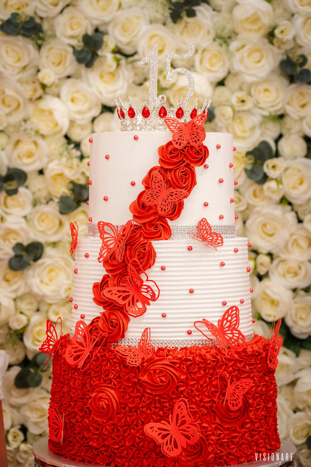 Pastel rojo con corona y mariposas